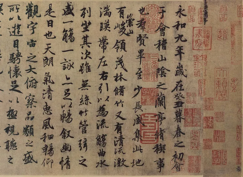 縦書きの行書の文字がならぶ古い書の巻物の一部。右はしに永和九年の文字があり、多くの朱色の印がおされている