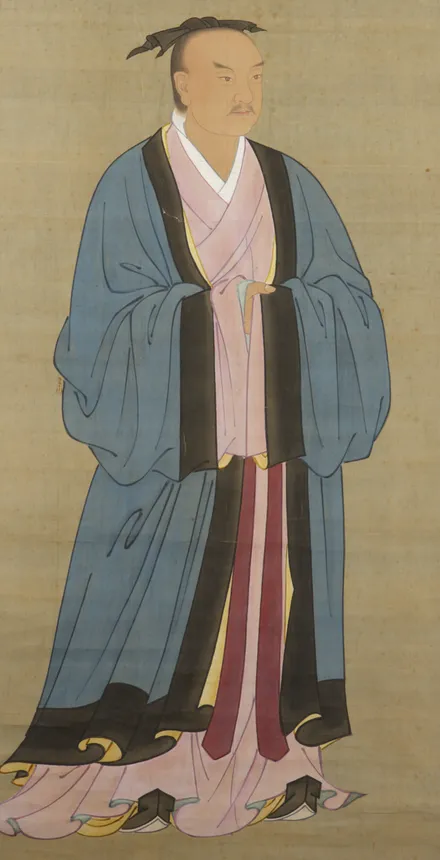 黒いふちどりの青い上着に桃色の衣を重ね、頭に小さなまげを結んだ男性が立っている、古い中国の肖像画