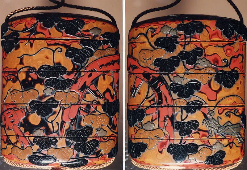 赤と黒のうるしぬりの小さな箱の表と裏。つる草がはう、こわれた車輪のそばに、銀色のかまきりがいる